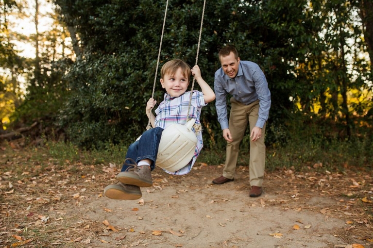 daddy pushing son on a swing