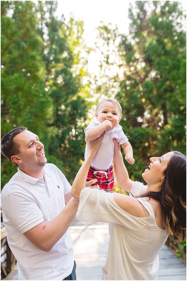 parents lifting baby boy in the air