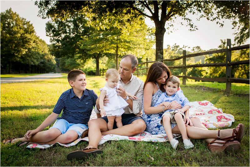 family posing on blanket 
