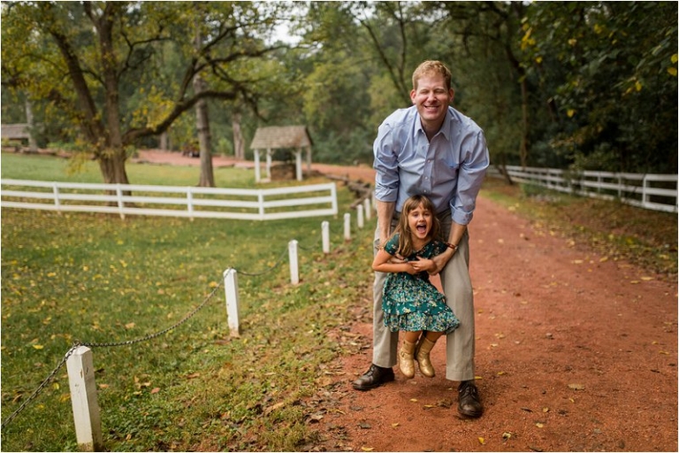 silly faced dad picking up daughter