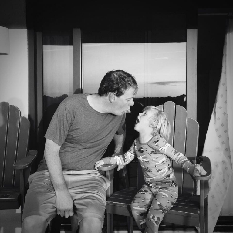 dad sticking his tongue out at son