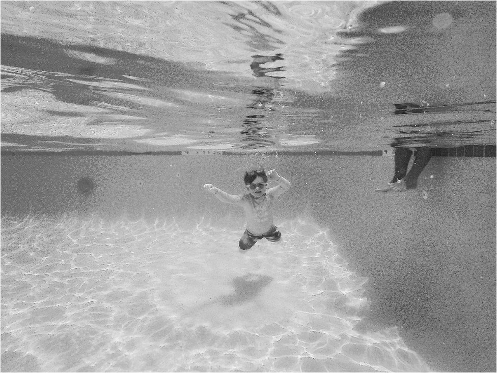 black and white underwater photograph, boy swimming