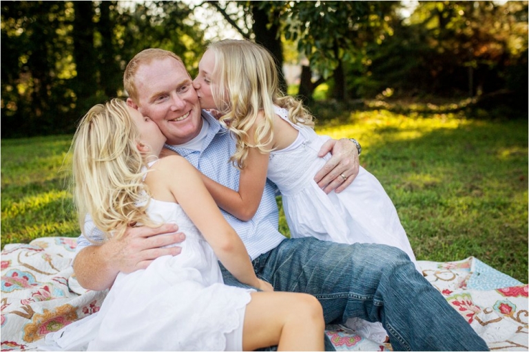 little girls kissing their dad on the cheek