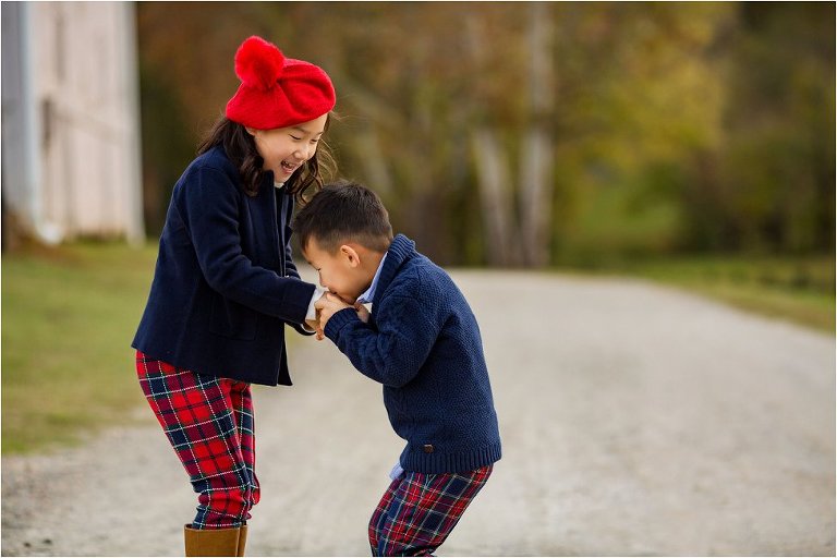 Little brother kissing big sister's hand.