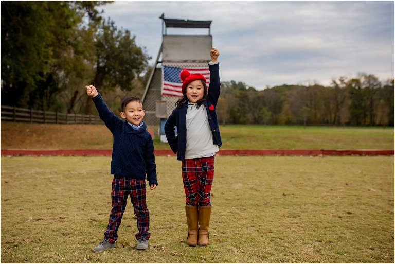 Brother and sister doing their best Statue of Liberty impression in front of American flag.