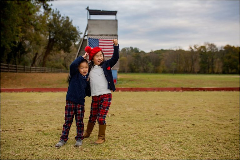 Brother and sister doing their best Statue of Liberty impression in front of American flag.