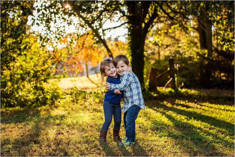 Twin brother and sister hugging in the golden light