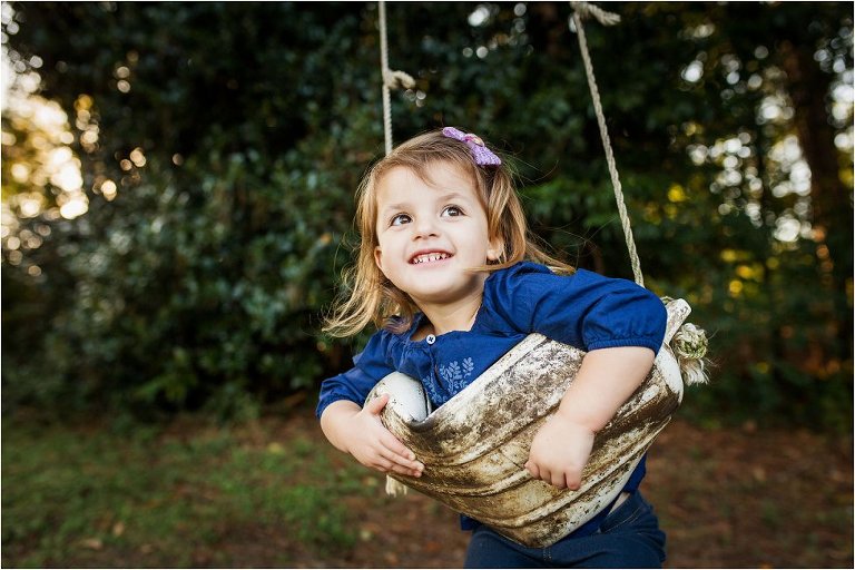 Little girl playing on a swing