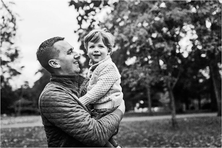 father holding his son in his arms in black and white