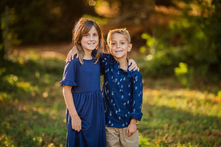 Sister and brother, both in blue, hugging