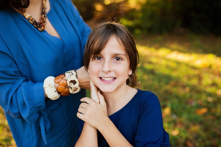 mom pulling her daughter's hair back into a ponytail.