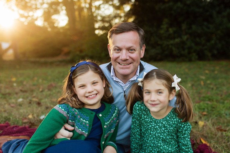 little girls leaning back into their dad's arms.
