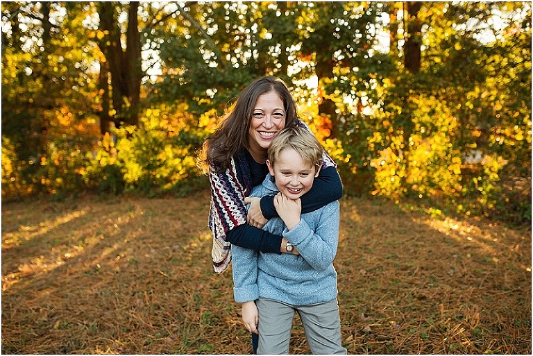 Mom with her arms wrapped around her little boy, pulling him close to her,