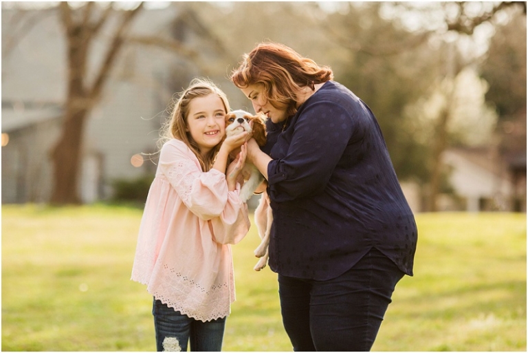 Mom and dog hugging their Cavalier King Charles puppy in Roswell, Georgia