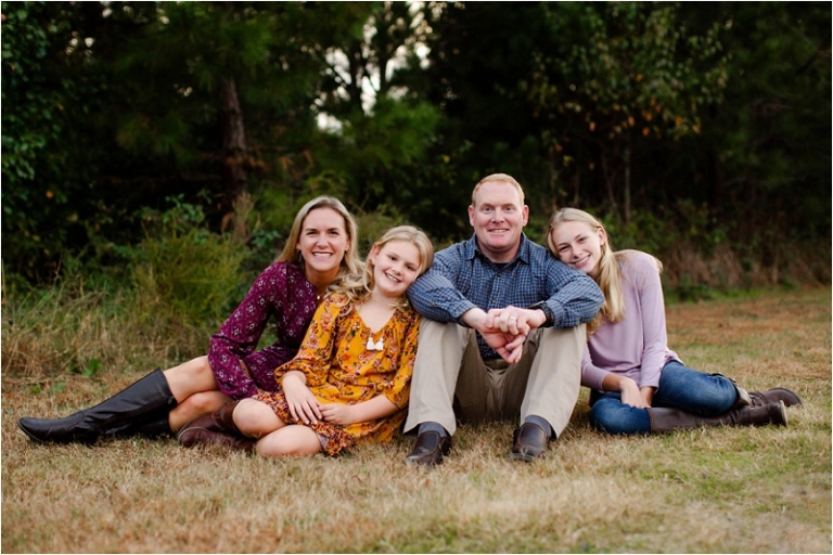 Beautiful family, gathered in a lovely pose while sitting in the grass.  