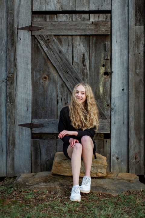 Wheeler High School Senior posing in front of a barn door