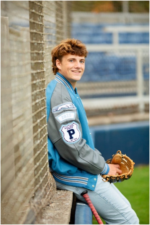 Candid photo of senior guy laughing while holding baseball glove during laid-back portrait session