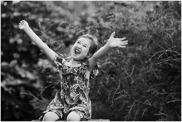 Candid black and white photo of little girl in a truly happy moment